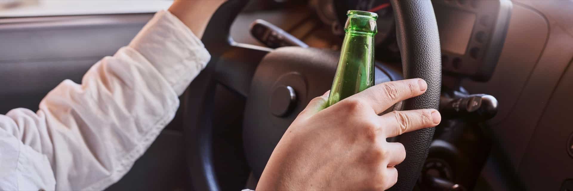 Man holding beer sitting in car